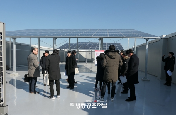 준공식에 참석한 관계자들이 건축물 옥상에 설치된 태양광 전지판을 살펴보고 있다.