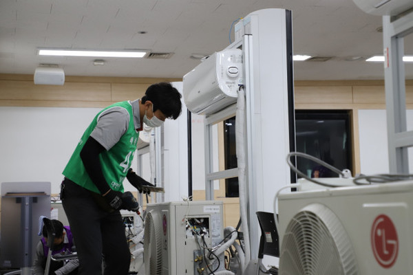 LG전자 ‘2022 한국 서비스 올림픽’에 참가한 서비스 매니저가 에어컨 실외기를 수리하고 있다([사진 = LG전자)