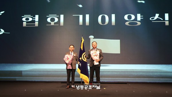 한굴설비기숧벼회 제28기 김철영 회장과 제29기 박종찬 차기 회장이 협회기 이양식 후 기념촬영을 하고 있다